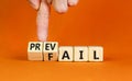 Prevail or fail symbol. Concept words Prevail or Fail on wooden cubes. Businessman hand. Beautiful orange table orange background