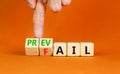 Prevail or fail symbol. Concept words Prevail or Fail on wooden cubes. Businessman hand. Beautiful orange table orange background