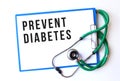 PREVENT DIABETES text on a medical folder and stethoscope on white background