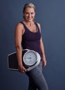 Prevention is always better than cure. Studio portrait of an attractive mature woman holding a weightscale against a Royalty Free Stock Photo