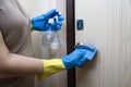 Prevention of the coronavirus pandemic treatment of apartment handles with disinfectant in protective gloves, medicine virus