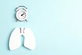 Prevention of pulmonary disease. Lung symbol and alarm clock on a blue background with copy space for text Royalty Free Stock Photo