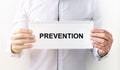 Prevention word on white paper in male hand of businesman