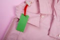 Price tag hang over pink shirt close up view - Image Royalty Free Stock Photo