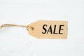 price tag label with word SALE on wooden background One paper blank tags with word SALE with rope on wooden background. Royalty Free Stock Photo