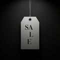 Price tag is suspended by a metallic string against a dark backgroun Royalty Free Stock Photo
