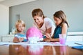 Priceless moments with my small family. a young mother helping her two small children with their art project at home. Royalty Free Stock Photo