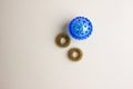 A prickly plastic blue massage ball isolated against a light background. Next to the ball are prickly rings for