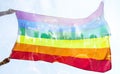 Colorful LGBT flag blows in the breez over crowd