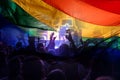 Colorful LGBT flag blows in the breez over crowd