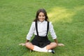 Pride In Excellence. cute smiling confident schoolgirl relax on green grass. happy childhood. back to school. Small girl