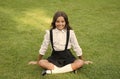 Pride In Excellence. cute smiling confident schoolgirl relax on green grass. happy childhood. back to school. Small girl Royalty Free Stock Photo