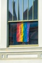 Pride flag in sunlit window of house or apartment building in San Francisco California Royalty Free Stock Photo