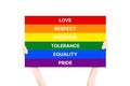 Pride Month 2020 vector banner template with the LGBT person holding multicolored poster as a symbol of LGBT community.