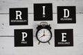 PRIDE Personal Responsibility In Delivering Excellence with alarm clock on wooden background Royalty Free Stock Photo