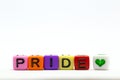 PRIDE word written on various rainbow cubes isolated on white background, with colorful symbol of heart lgbt concept Royalty Free Stock Photo