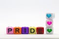 PRIDE word written on various rainbow cubes isolated on white background, with colorful symbol of heart lgbt concept Royalty Free Stock Photo