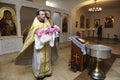 Priest baptizing child in a rural church holding baby on hands, Christening for baby. Bucha, Ukraine