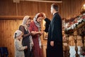 a priest blesses a woman with her daughters in an Orthodox church after a festive church mass