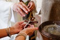 A priest blessing rosary and crucifix with holy water Royalty Free Stock Photo