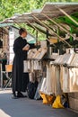 Priest at book stall along river Seine.