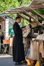 Priest at book stall along river Seine.