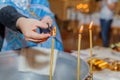 Priest burning hair in candle flame in church