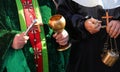 priest with cassock and aspergillum while performing the blessing also with holy water and incense during the holy mass