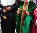 priest with cassock and aspergillum with holy water and incense during the holy mass