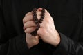 Priest in cassock with beads praying, closeup Royalty Free Stock Photo