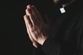 Priest in cassock praying on dark background, closeup Royalty Free Stock Photo