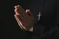 Priest in cassock praying on dark background, closeup Royalty Free Stock Photo