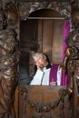 Priest in confession booth Royalty Free Stock Photo