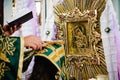 Priest covers bride head a cassock and cross, in the church. Near the icon. Close up