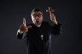 Priest holding cross of wood praying