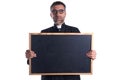 Priest holding empty blackboard copy space Royalty Free Stock Photo