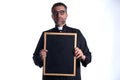 Priest holding empty blackboard copy space Royalty Free Stock Photo
