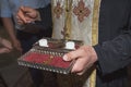 The priest holds church utensils, glans, ceremony of water baptism, various objects needed for baptism christening