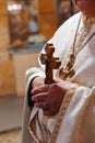 The priest holds the cross in the church