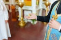 The priest holds in his hand the wax with the child& x27;s hair cut off at baptism.