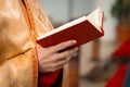 The priest holds and read the Bible in his hands.