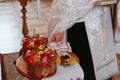 Priest holds two golden rings against background of wedding crowns during Wedding ceremony in Orthodox Ukrainian church