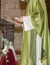 Priest with holy wafer in hand, prepared to give communion during a mass inside a church.