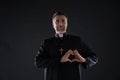 Priest man doing a heart shape with fingers