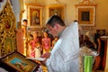 The priest performs the rite of christening of child in Ukrainian church