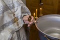 Priest prepare to baptize the child. Font for taking faith.The hands of the priest near the Epiphany bath Royalty Free Stock Photo