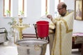 The priest prepares for the baptism ceremony of the child.