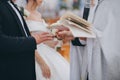 Priest putting a ring on groom`s finger during wedding ceremony