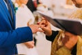 The priest putting a ring on groom's finger during traditional wedding in church