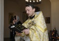 Priest reading Bible in a rural church. Baptizing for baby